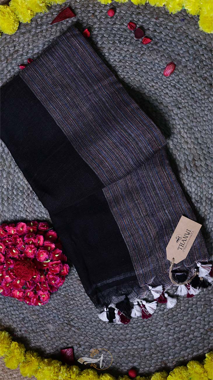 Pair of dark gray socks with a pattern on a textured surface with colorful flowers.