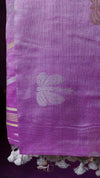 Close-up of a purple fabric with floral patterns and tassels.