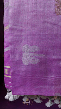 Close-up of a purple fabric with floral patterns and tassels.