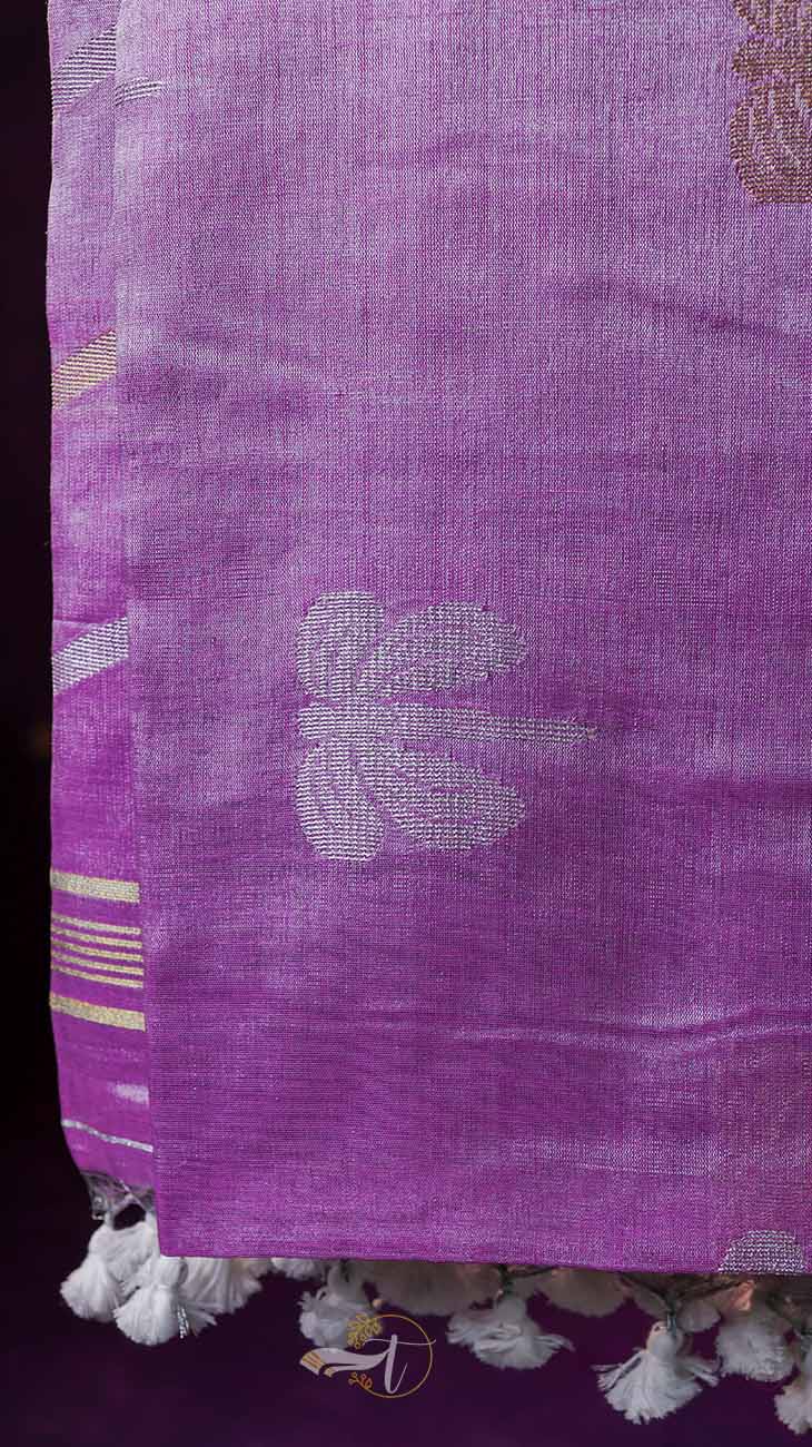 Close-up of a purple fabric with floral patterns and tassels.