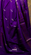Purple fabric with gold patterns and a brand logo in the corner