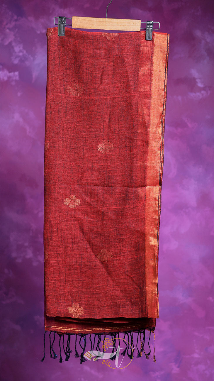 Red fabric with gold patterns and fringes on a purple background