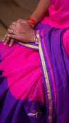Close-up of a person wearing a pink and purple saree with gold border.