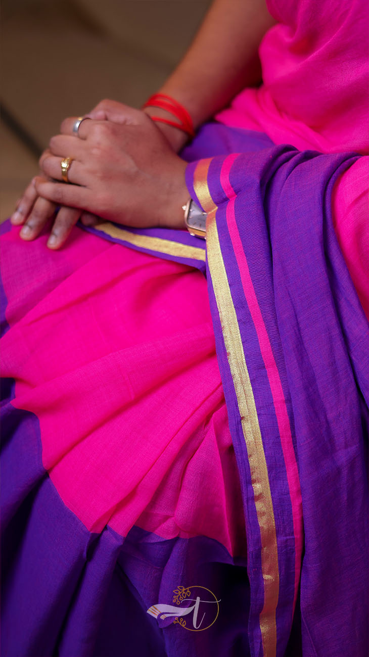 Close-up of a person wearing a pink and purple saree with gold border.
