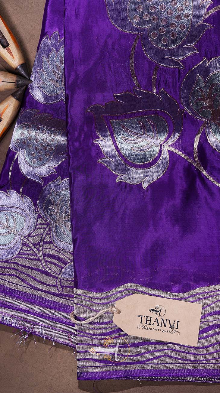 Purple fabric with silver floral patterns and a Thani brand tag.