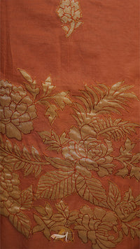 Close-up of orange fabric with gold floral embroidery