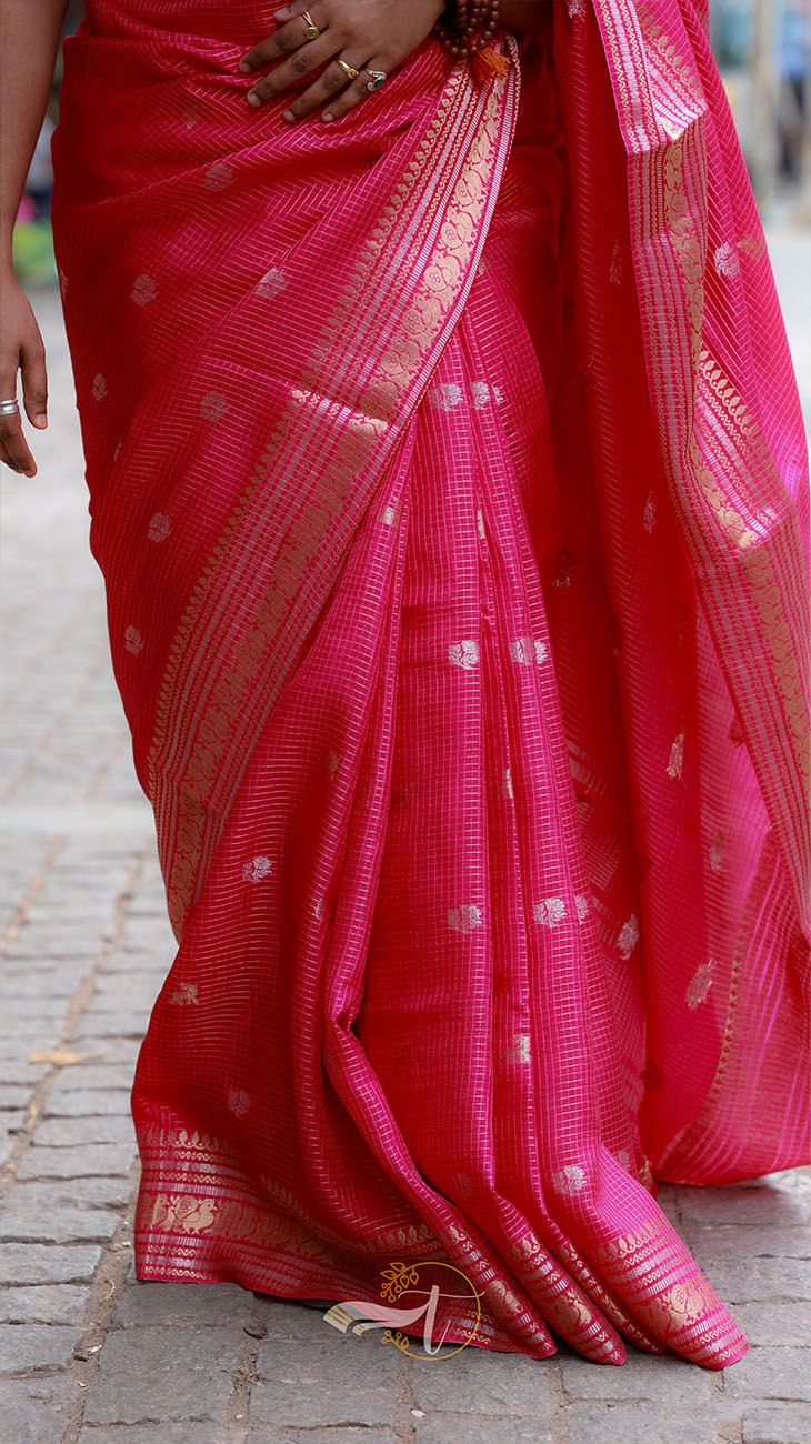 Red saree with gold border on a paved ground