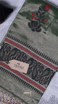 Embroidered fabric with intricate patterns and a Thambi label on a textured surface.