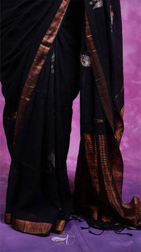Black saree with brown border on a purple background