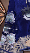 Blue fabric with silver floral embroidery on a brown background