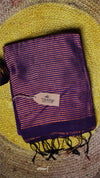 Purple scarf with a brand tag on a textured yellow and brown background