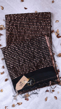 Black and brown patterned scarf with a brand tag on a light gray background