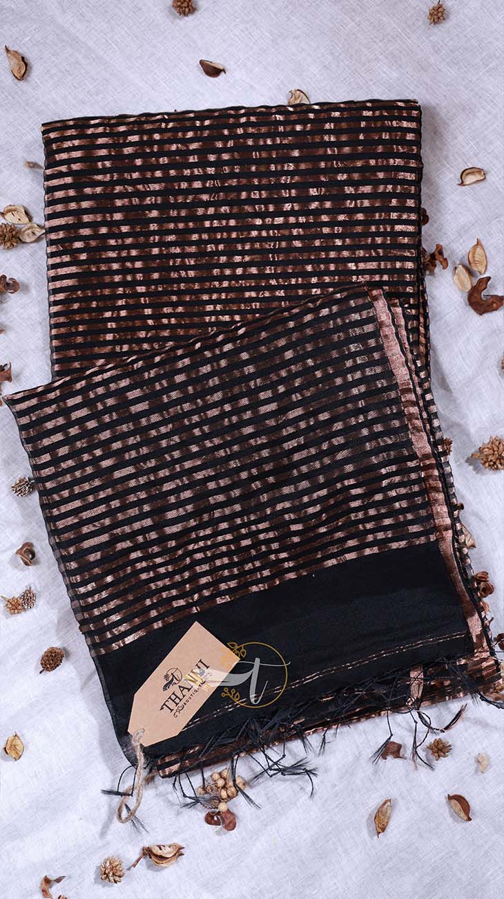 Black and brown patterned scarf with a brand tag on a light gray background