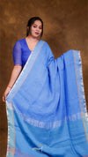 Woman wearing a blue saree with a plain background