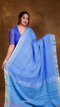 Woman wearing a blue saree with a plain background