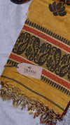 Yellow scarf with black floral patterns and red accents, branded 'THANVI', on a light gray background.