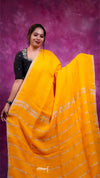 Woman wearing a yellow saree with a purple background