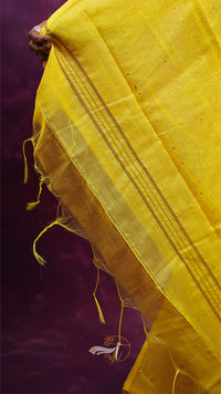 Close-up of a yellow fabric with intricate patterns on a dark background