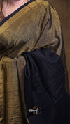 Close-up of a person wearing a gold and black garment with a visible brand logo.