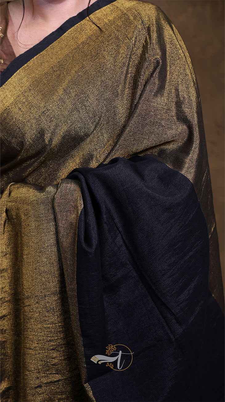 Close-up of a person wearing a gold and black garment with a visible brand logo.
