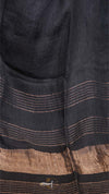 Close-up of a dark fabric with brown stripes and a brand logo.