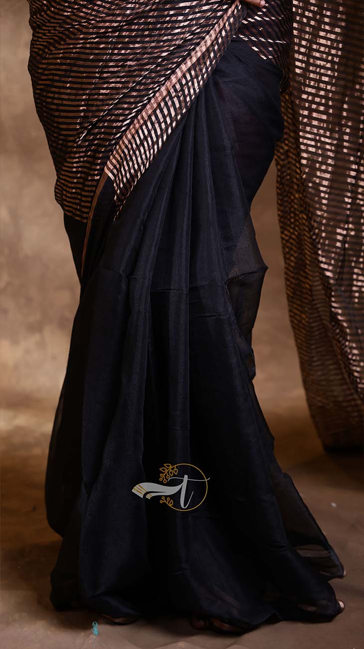 Black saree with a textured blouse draped over a brown background