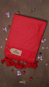 Red striped towel with tassels on a brown background