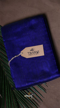 Blue velvet pouch with a 'THANVI' tag on a textured surface