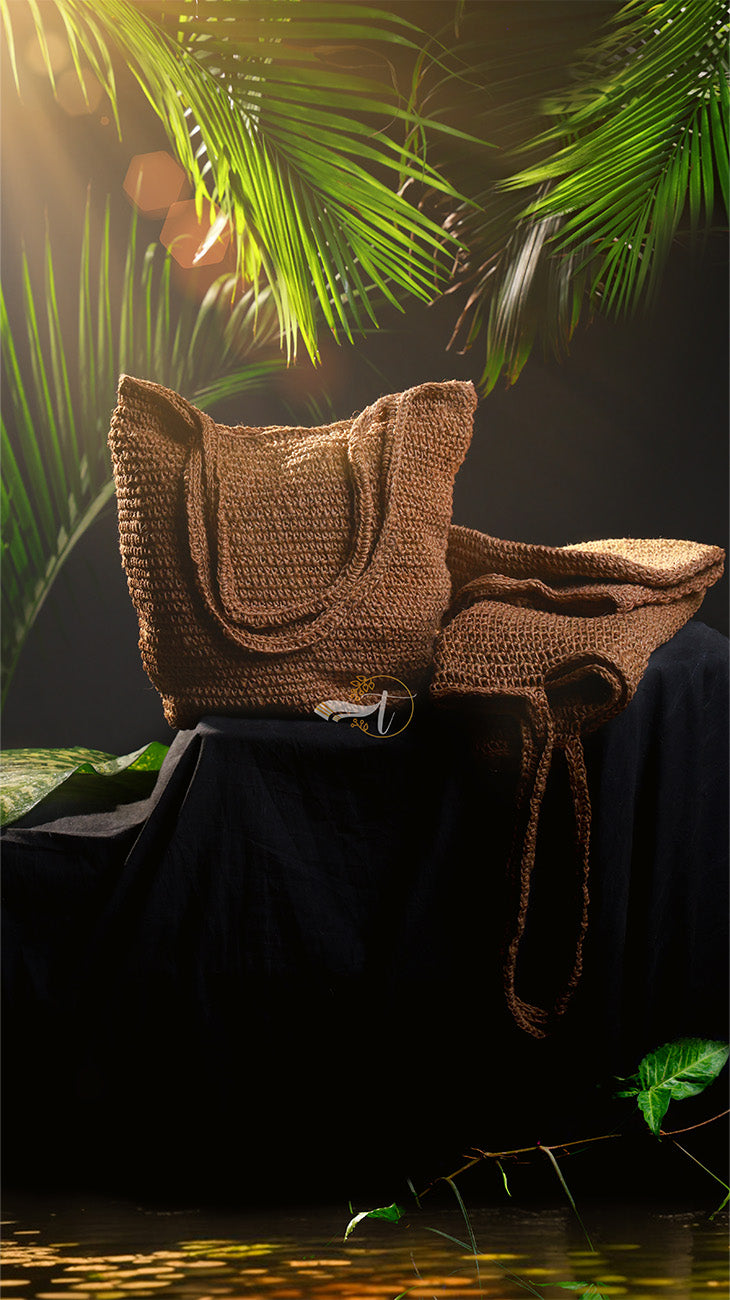 Brown woven basket and blanket on a dark surface with green leaves in the background