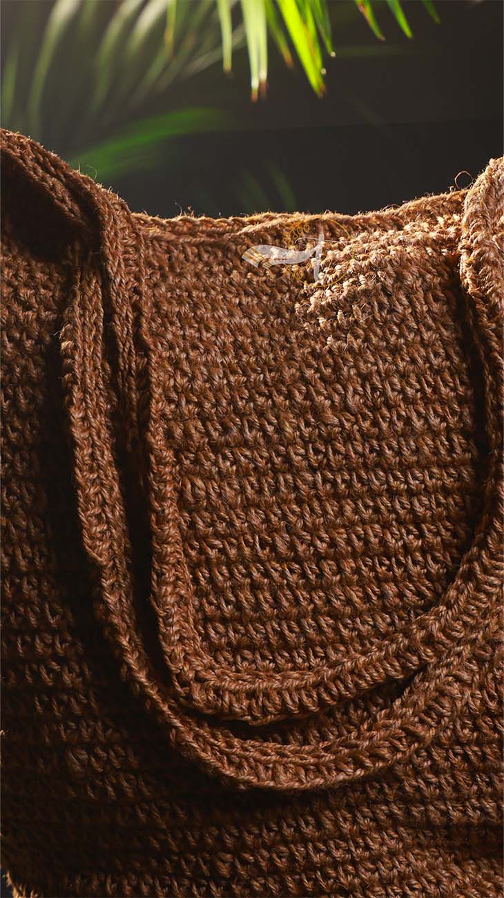 Close-up of a brown textured bag with a blurred green plant background