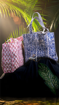 Two patterned bags on a dark surface with a blurred natural background