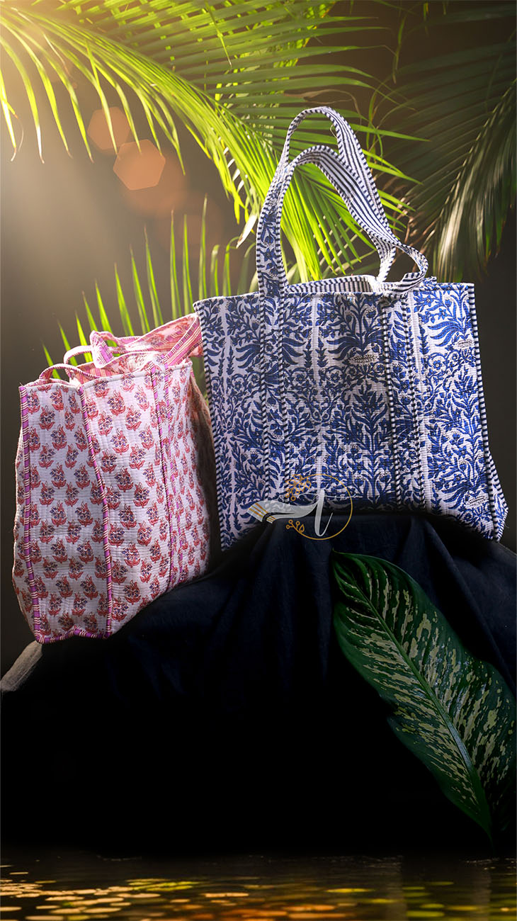 Two patterned bags on a dark surface with a blurred natural background