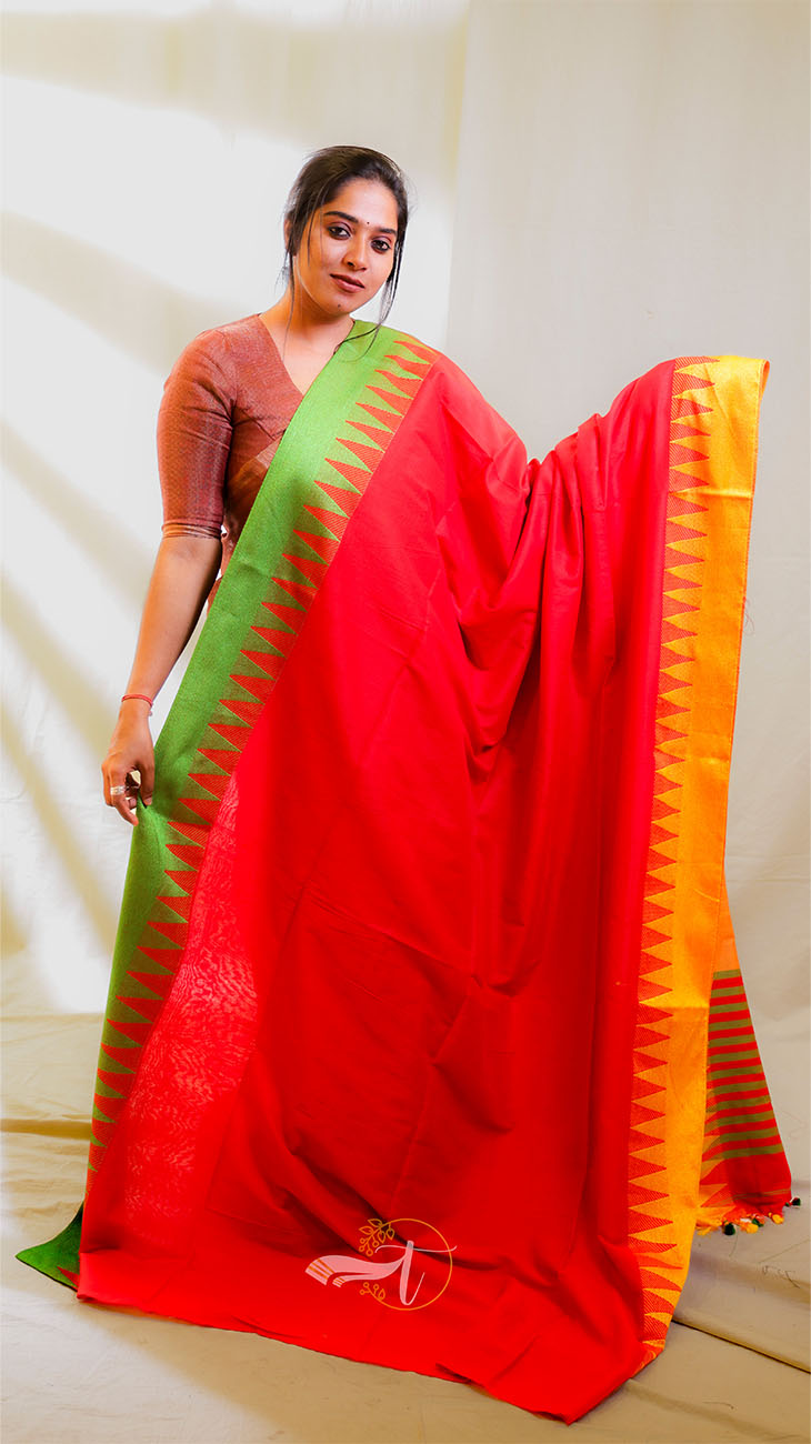 Woman holding a red, green, and orange saree against a white background