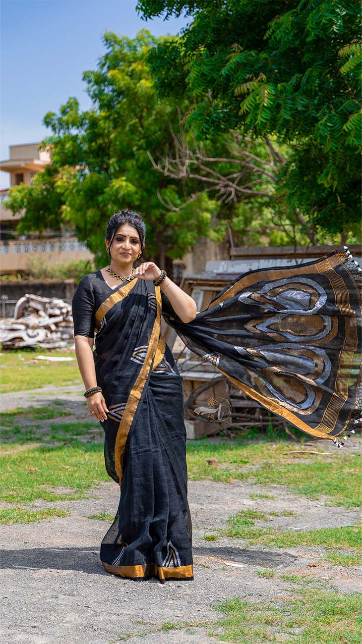 Woman in a black saree with gold border outdoors