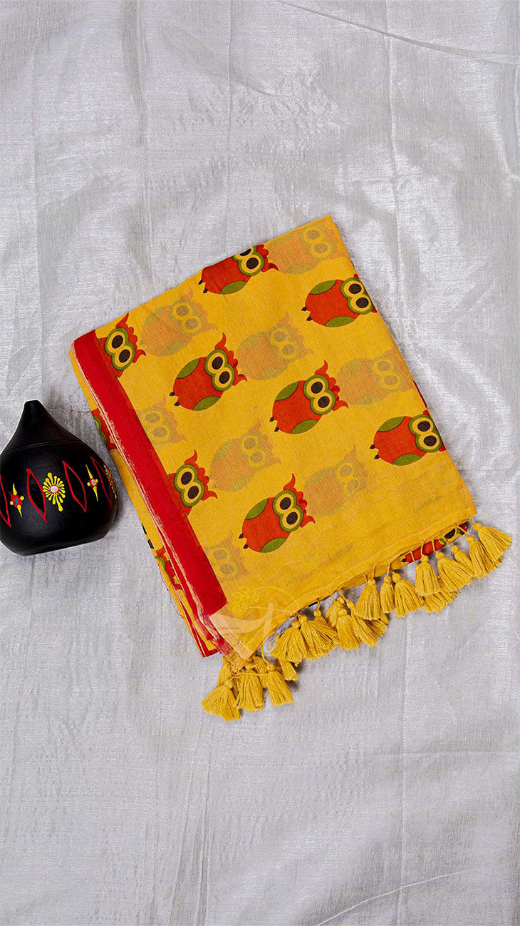 Yellow towel with owl pattern and red border on a white fabric background