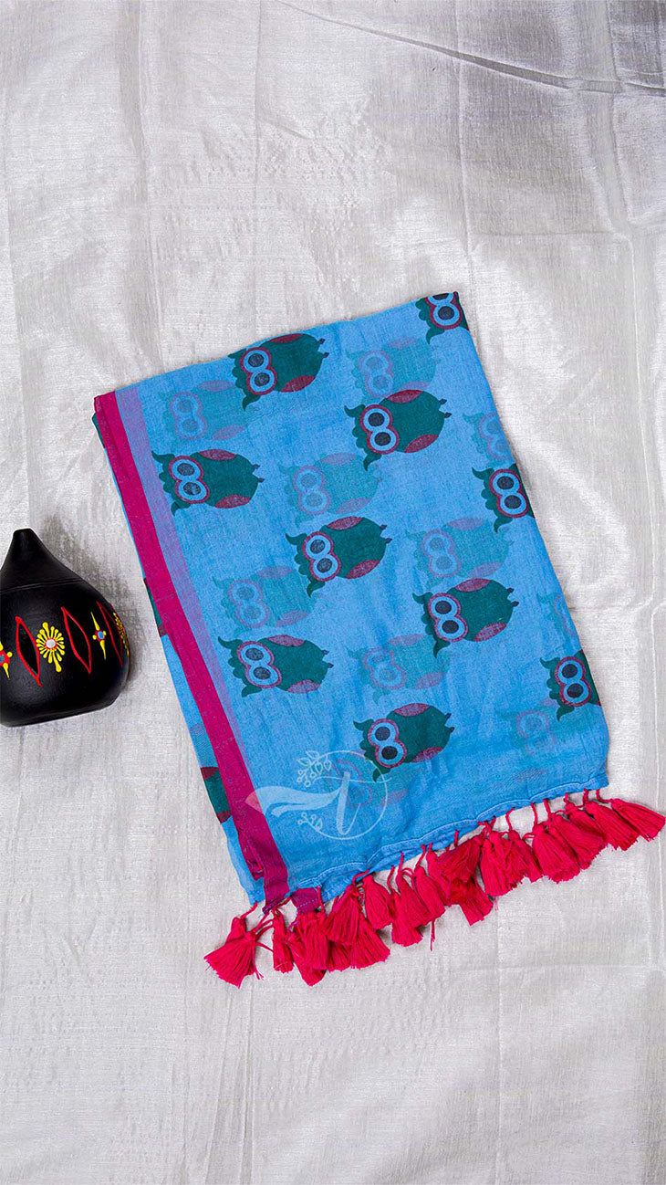 Blue towel with owl pattern and red tassels on a white background