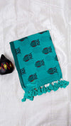 Teal towel with owl pattern and tassels on a white background