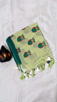 Green fabric with owl pattern and tassels on a white background
