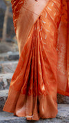 Orange saree with a pattern draped over a stone surface