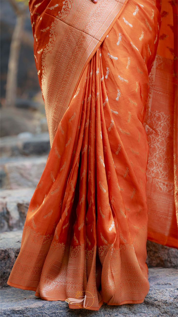 Orange saree with a pattern draped over a stone surface
