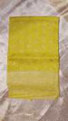Yellow saree with subtle patterns on a textured surface