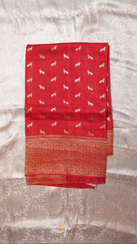 Red fabric with white patterns on a textured beige background