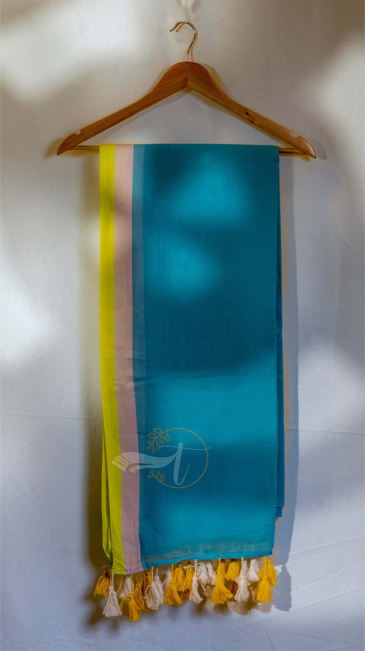 Turquoise scarf with yellow and pink stripes hanging on a wooden hanger against a white wall.