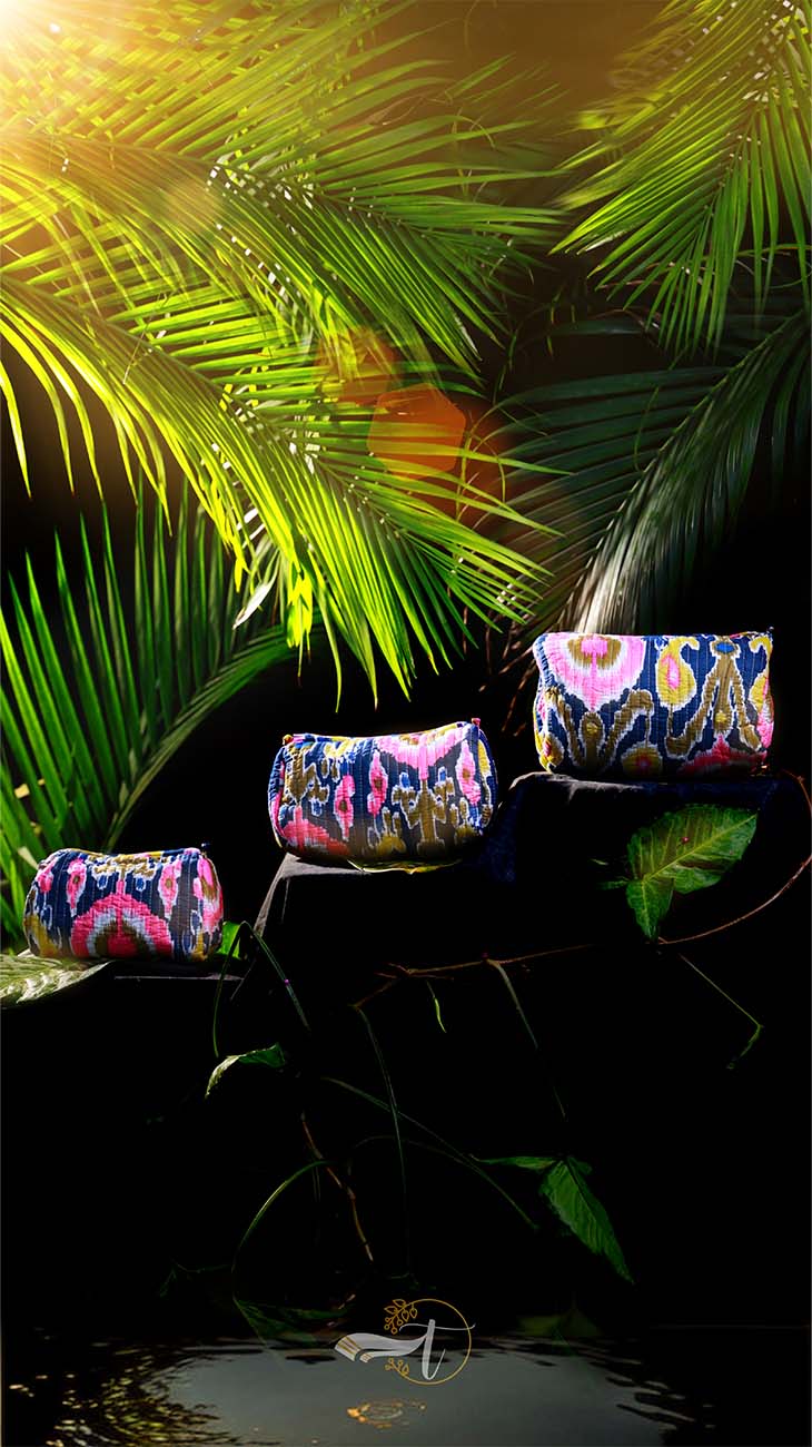 Colorful handbags on a reflective surface with green leaves in the background