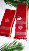 Red saree with gold border and white floral design on a white background with green leaves.