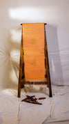 Orange fabric on a wooden stand against a white background