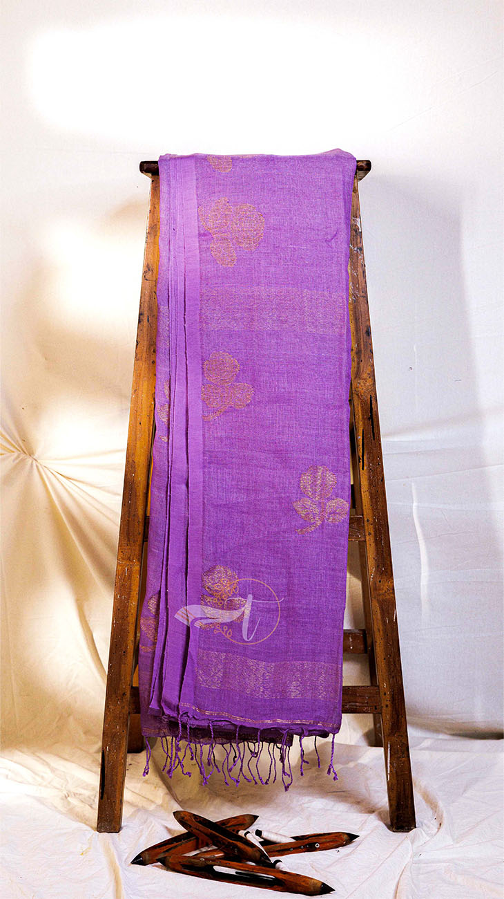 Purple scarf with floral patterns draped over a wooden stand against a white background