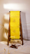 Yellow towel draped over a wooden ladder against a white wall.