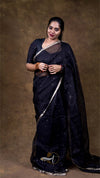 Woman wearing a dark blue saree with a brown background