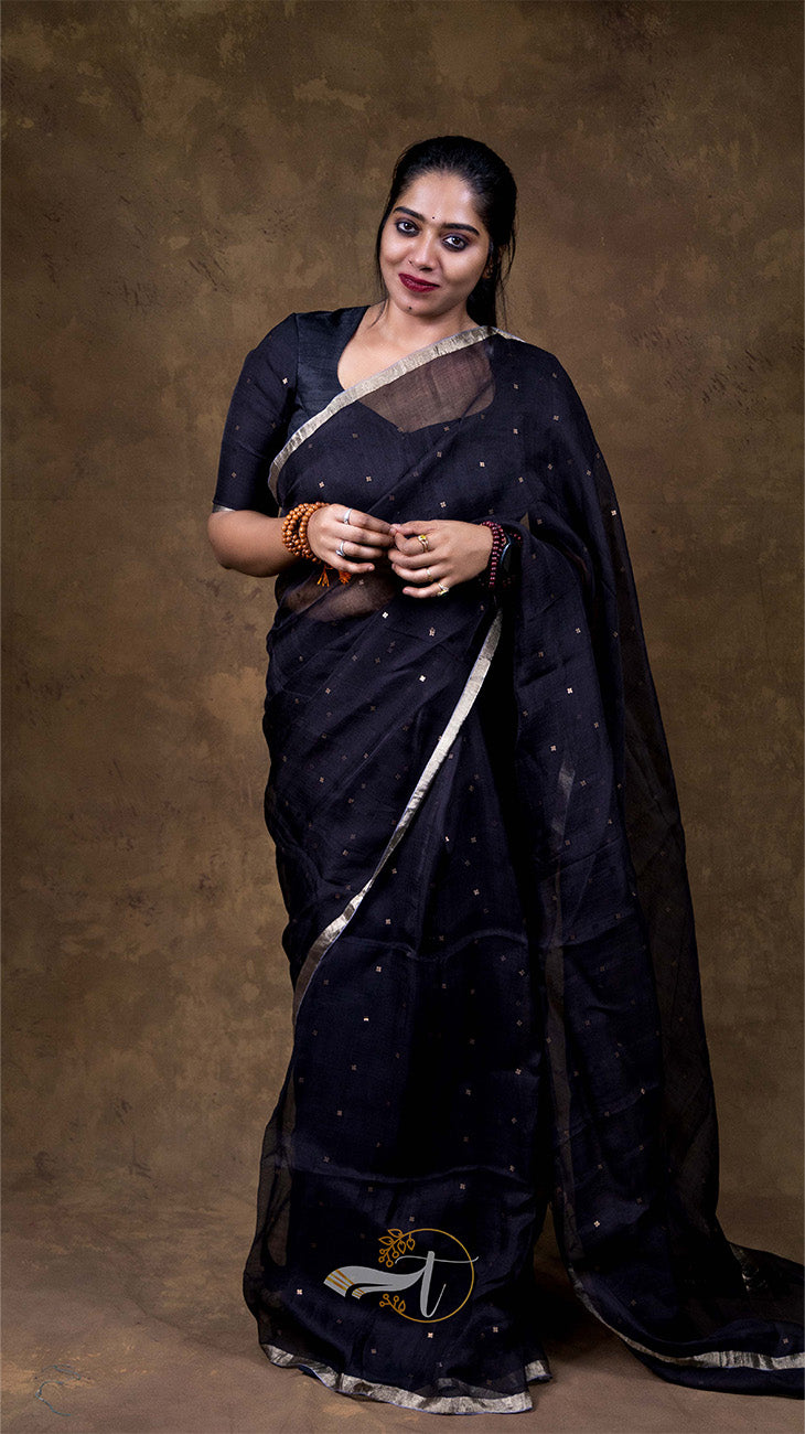 Woman wearing a dark blue saree with a brown background
